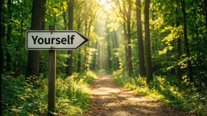 一個沿著陽光普照的森林小徑指向「Yourself」的標誌。