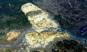 從高空俯瞰森林山區的大型山泥傾瀉，河流流經碎石。