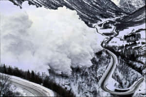 雪崩從山谷中傾瀉而下，掩埋了一條蜿蜒的道路。
