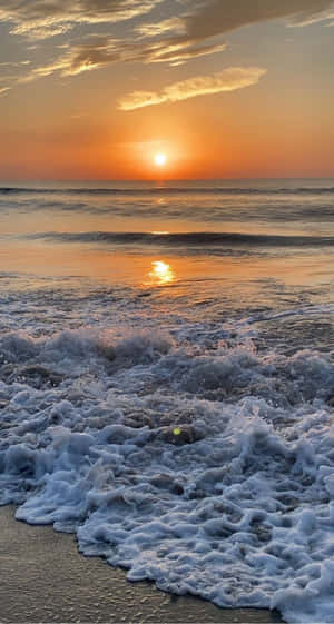 夕陽下的海洋，海浪拍打沙灘