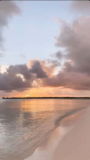 平靜海洋上的夕陽，白色沙灘和柔軟雲朵