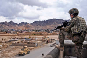 身穿迷彩服的士兵俯瞰著一個有山脈和下方軍用車輛的小鎮。