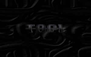 黑暗波紋布料背景上的金屬文字 TOOL