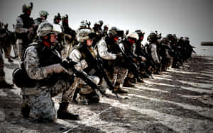 一排身穿沙漠迷彩的武裝士兵跪成隊形。