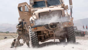 士兵在塵土飛揚的沙漠景觀中靠近一輛裝甲軍用卡車移動。