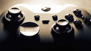 黑色遊戲手掣嘅特寫，帶有發光嘅高光同深邃嘅陰影。 — Xbox GIF 壁紙