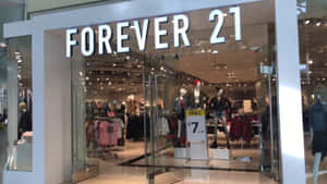 Forever 21服裝店，透過玻璃門可見人體模型和促銷標誌。 — 2560x1440 壁紙