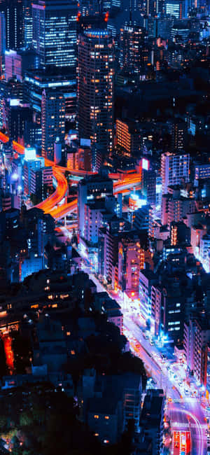 繁忙霓虹城市的夜晚航拍，發光的建築和車流。 — 沙灘 壁紙
