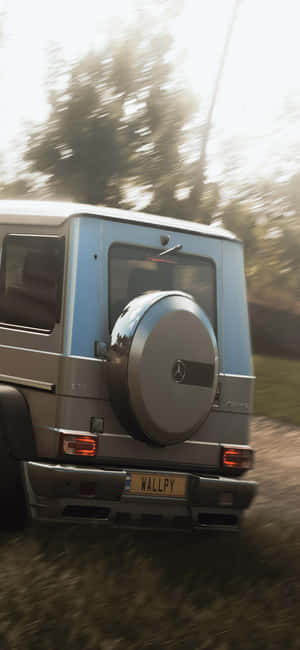 銀色 Mercedes G-Wagen 在日落時分穿越森林。