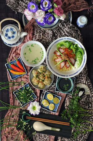 有麵條、雲吞湯和配菜的亞洲餐點，放在圖案紡織品上。