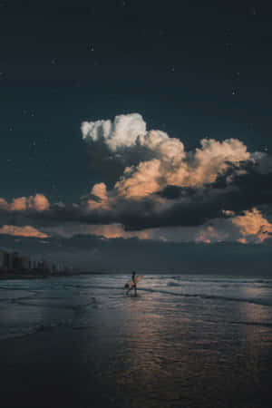 一個衝浪者在繁星點點的夜空下，頂著發光的雲朵走進海洋。