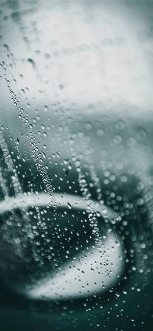 玻璃上的雨滴，帶有青綠色和灰色調的模糊圓形