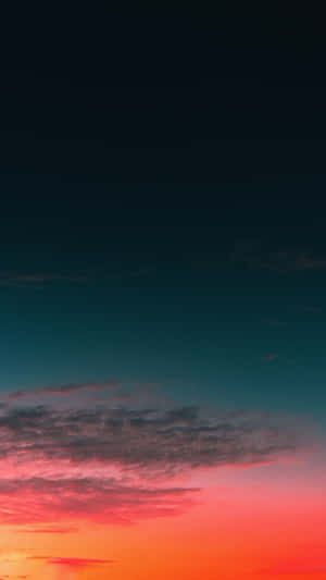 充滿活力的日落天空，帶有橙色和青色色調，以及暮色中的縷縷雲彩。
