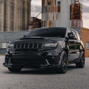 黑色Dodge Durango SRT停泊在生鏽的工業建築前。