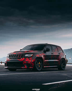 在暮色中停車場停泊的定制紅黑圖案Jeep SUV。