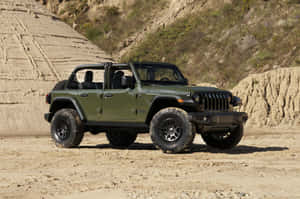 橄欖綠色Jeep Wrangler停在岩石結構附近的泥土上