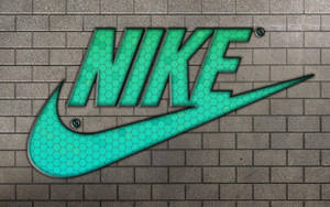 灰色磚牆上帶有六邊形圖案的青綠色Nike標誌。