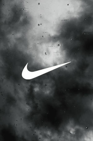 白色Nike標誌在雨窗上，背後有黑暗的暴風雲。