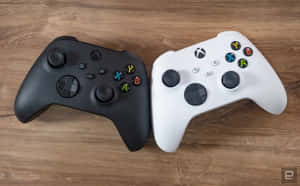 木桌上黑白Xbox手掣