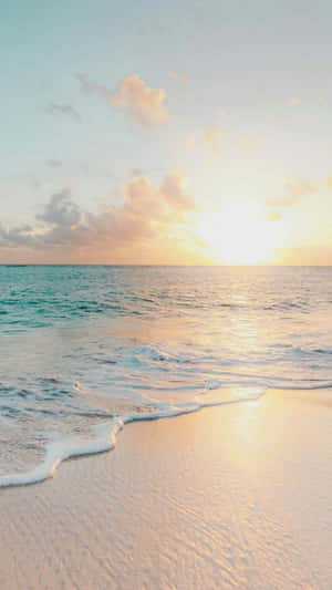 夕陽海浪沖刷沙灘，粉彩天空和雲朵