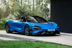 藍色McLaren 720S Spider開篷跑車停泊在戶外，靠近樹木和一座深色建築。 — 麥拿侖 GIF 壁紙