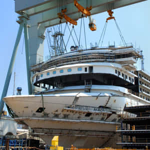 郵輪正在造船廠建造，起重機吊起船體分段。
