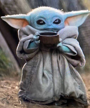 Baby Yoda 在戶外裹著灰色斗篷拿著杯子