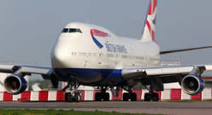 英國航空波音747在機場停機坪上，帶有紅色和白色屏障