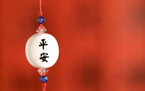 帶有和平中文字的白色陶瓷飾物掛在帶有藍色珠子的紅繩上。 — 中國新年 壁紙