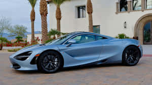 銀色McLaren 720S停泊在帶有棕櫚樹的豪宅前。