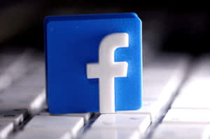 白色鍵盤上的藍色3D打印Facebook標誌立方體