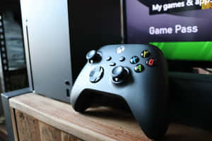 黑色Xbox手掣在木架上，旁邊是遊戲主機和電視。