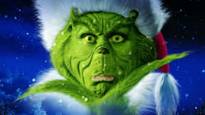 戴著聖誕帽的鬼靈精（Grinch）憤怒地望著飄雪的夜空