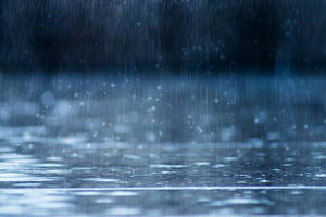 雨滴落在潮濕的表面，形成漣漪和閃光。 — 暴風 壁紙