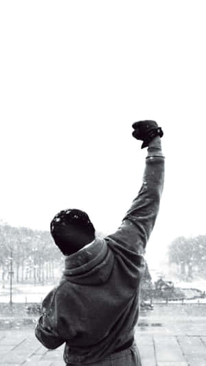穿連帽衫男子在雪街舉拳