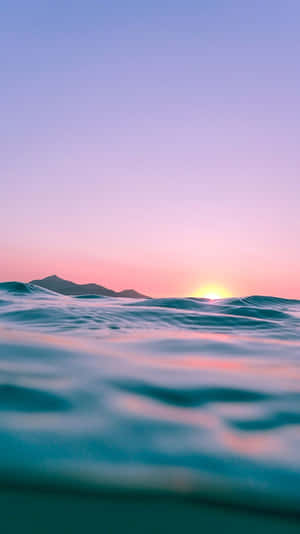 夕陽下的海洋，山巒剪影和寧靜的波浪