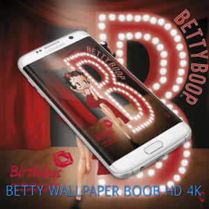 白色Samsung手機顯示Betty Boop生日壁紙，配有紅色窗簾和發光招牌。