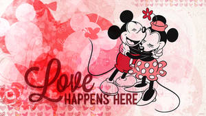 米奇和米妮老鼠在充滿愛意的擁抱中，伴有心形和「Love Happens Here」文字。 — 可愛情人節gif 壁紙