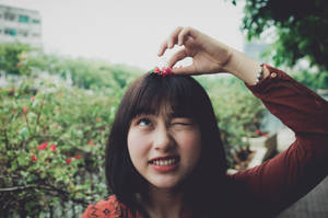 年輕女性眨眼並在戶外用手指做出心形。
