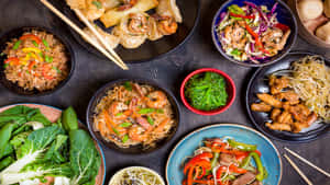 各種亞洲菜餚，包括餃子、麵條和沙律，排列在深色木桌上。
