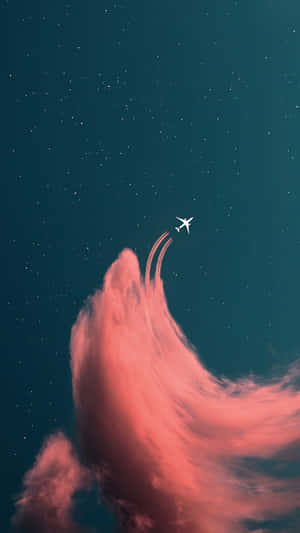一架飛機在繁星點點的夜空中飛過粉紅色的雲層。