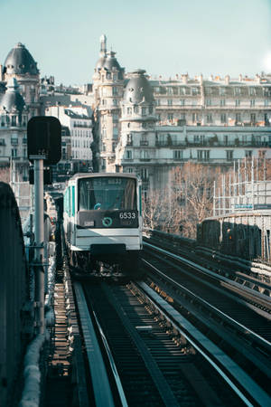白色巴黎地鐵列車在高架軌道上，背景有歷史建築。