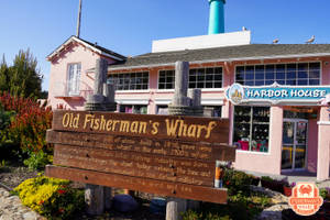 粉紅色Harbor House，帶有Old Fisherman's Wharf招牌和青綠色煙囪，在晴朗的天空下。 — 加州 壁紙