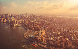 紐約市天際線和河流的日落鳥瞰圖，帶有金色光芒。