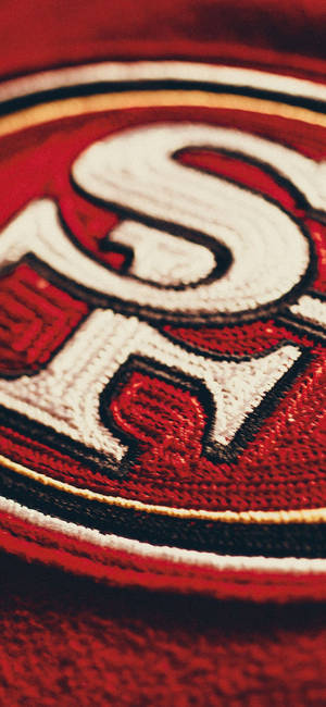 紅色布料上三藩市49人隊標誌刺繡的特寫。 — Galaxy S25 Edge 壁紙