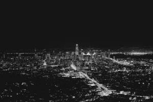 夜晚城市的鳥瞰圖，燈光明亮，高樓林立。