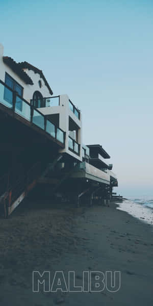 黃昏時分，高蹺上的現代海灘房屋與海浪