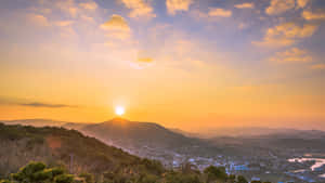 山上的夕陽，下方有小鎮