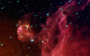 一個發光的紅色和藍綠色星雲，充滿了深空中的明亮星星。