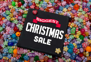 黑色標牌，寫有「Biggest Christmas Sale」，周圍環繞著色彩繽紛的字母和花朵珠子。